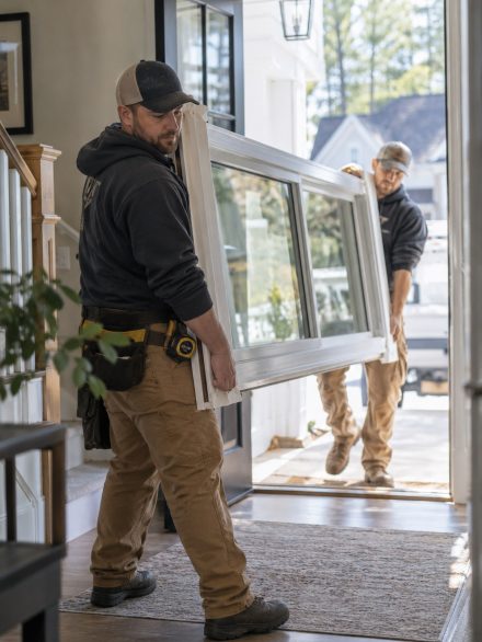 Crew performing Window Installation at a Canyon County - ID home while checking frame alignment, Technician reviewing Window Installation details beside a Kuna - ID home's newly fitted frame